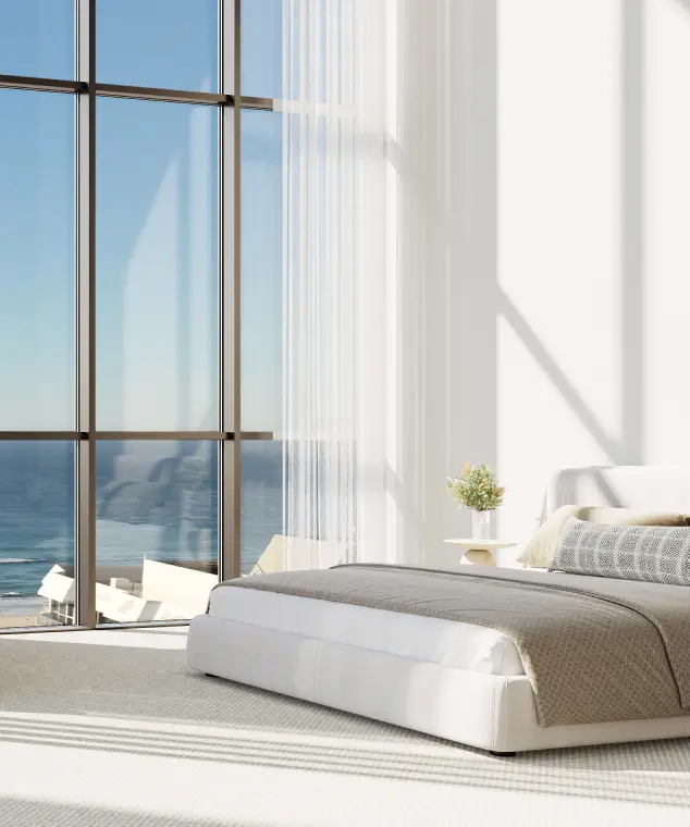 A serene bedroom with minimalist décor, large glass windows providing panoramic ocean views, and an abundance of natural light creating a tranquil ambiance.